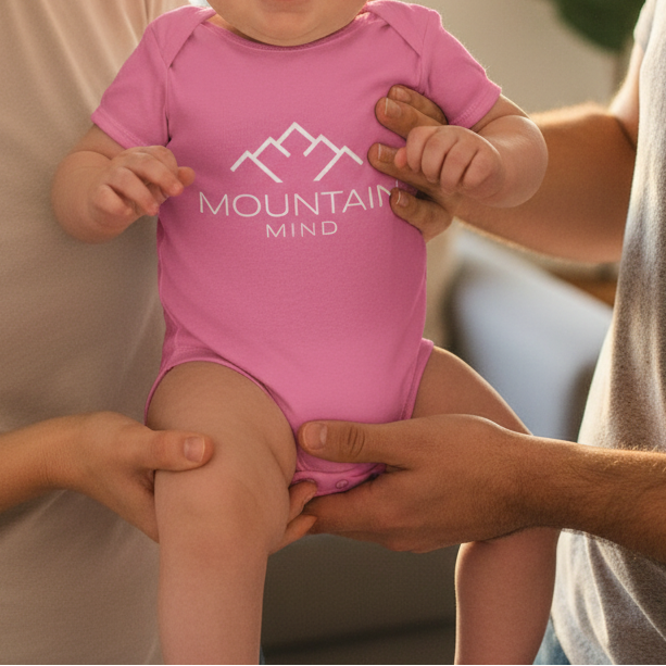 Ein Baby trägt einen Mountain Mind Strampler
