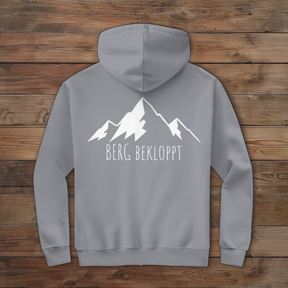 Ein grauer Hoodie mit weissem Berg bekloppt Logo auf dem Rücken 
