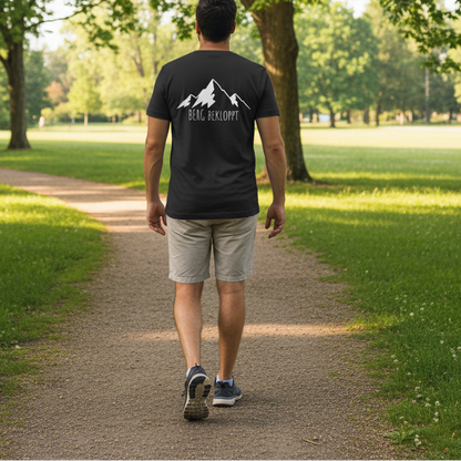 Ein Mann läuft in einem Park und trägt dabei ein schwarzes Berg Bekloppt Tshirt