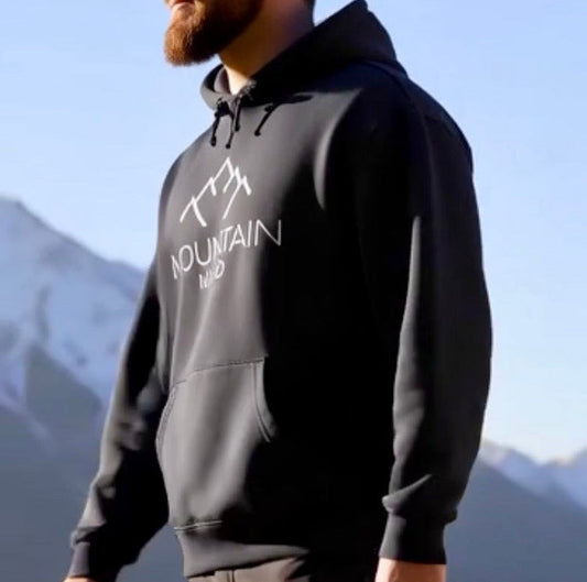 Ein Mann trägt einen Mountain Mind Hoodie während er mit seinem Hund wandert 