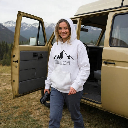 Eine junge Frau steigt aus einem Auto und trägt dabei das Berg Bekloppt Hoodie