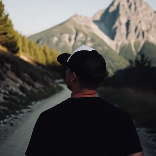 Ein Mann wandert und trägt dabei ein Cap von Mountain Mind